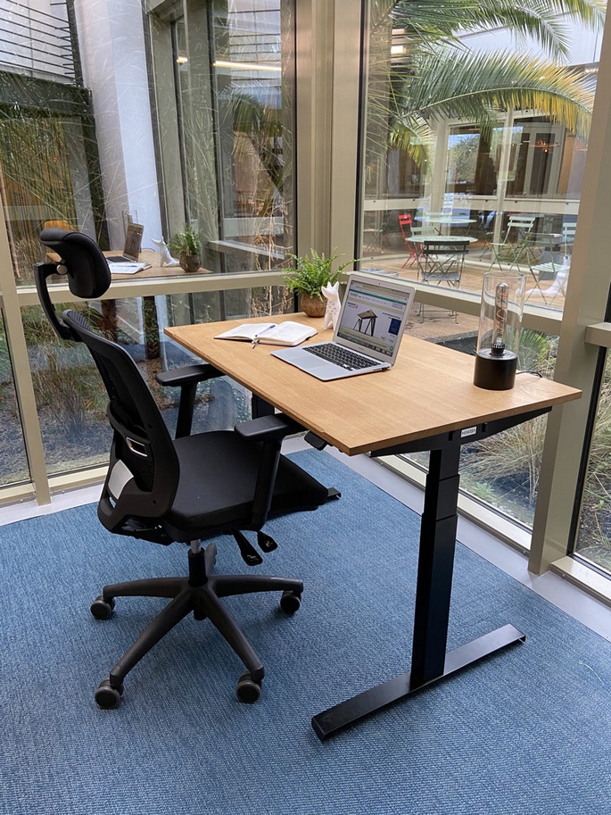 Bureau assis-debout r&eacute;glable en hauteur dans un bureau professionnel